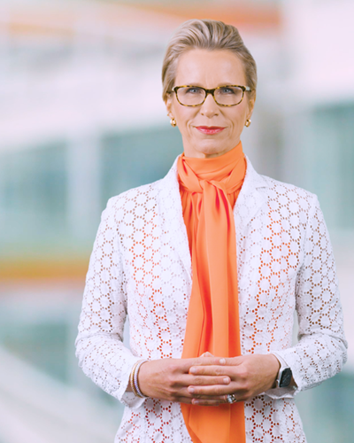 GSK CEO Emma Walmsley in orange shirt and white jacket
