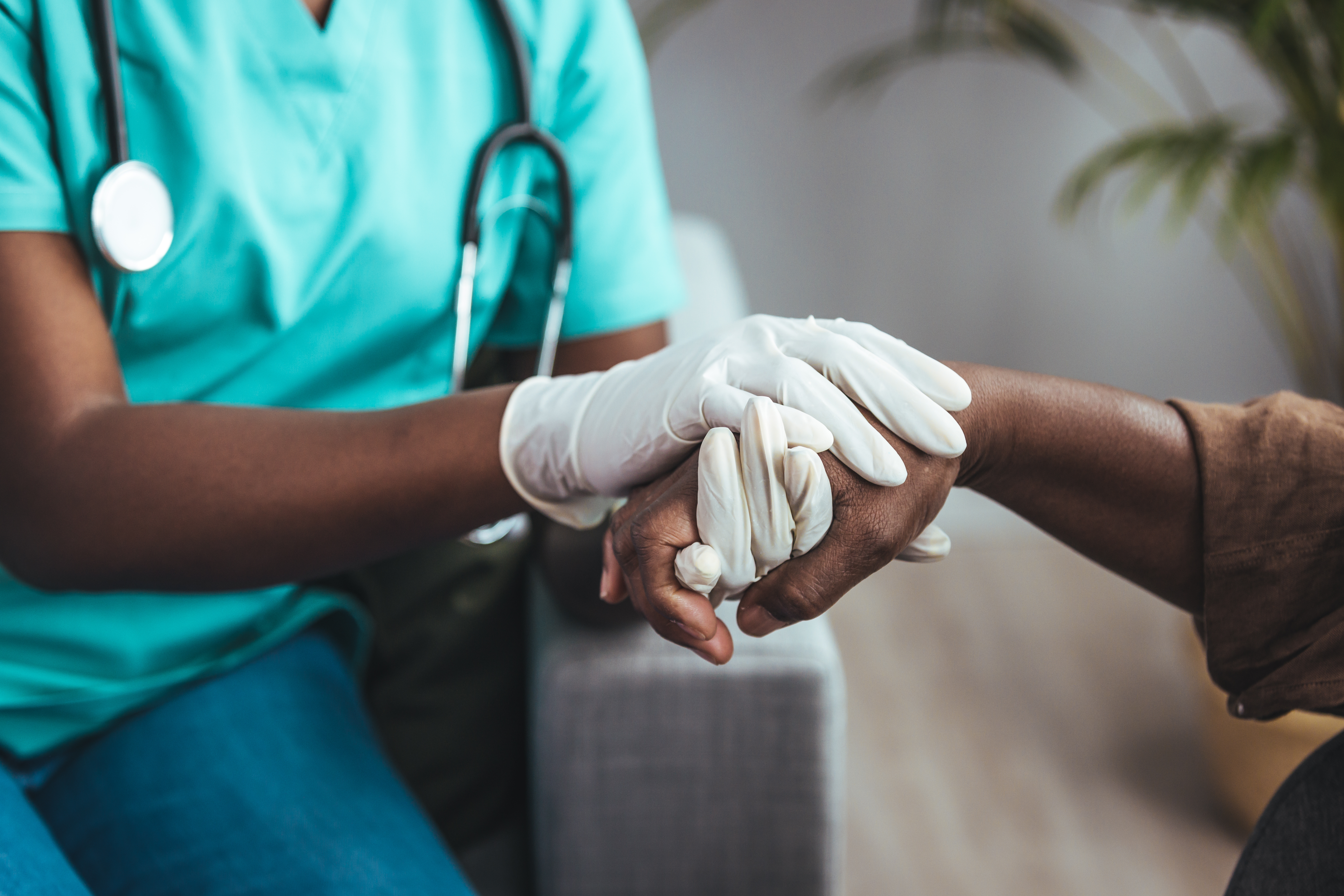 Medical professional holding a patients hand