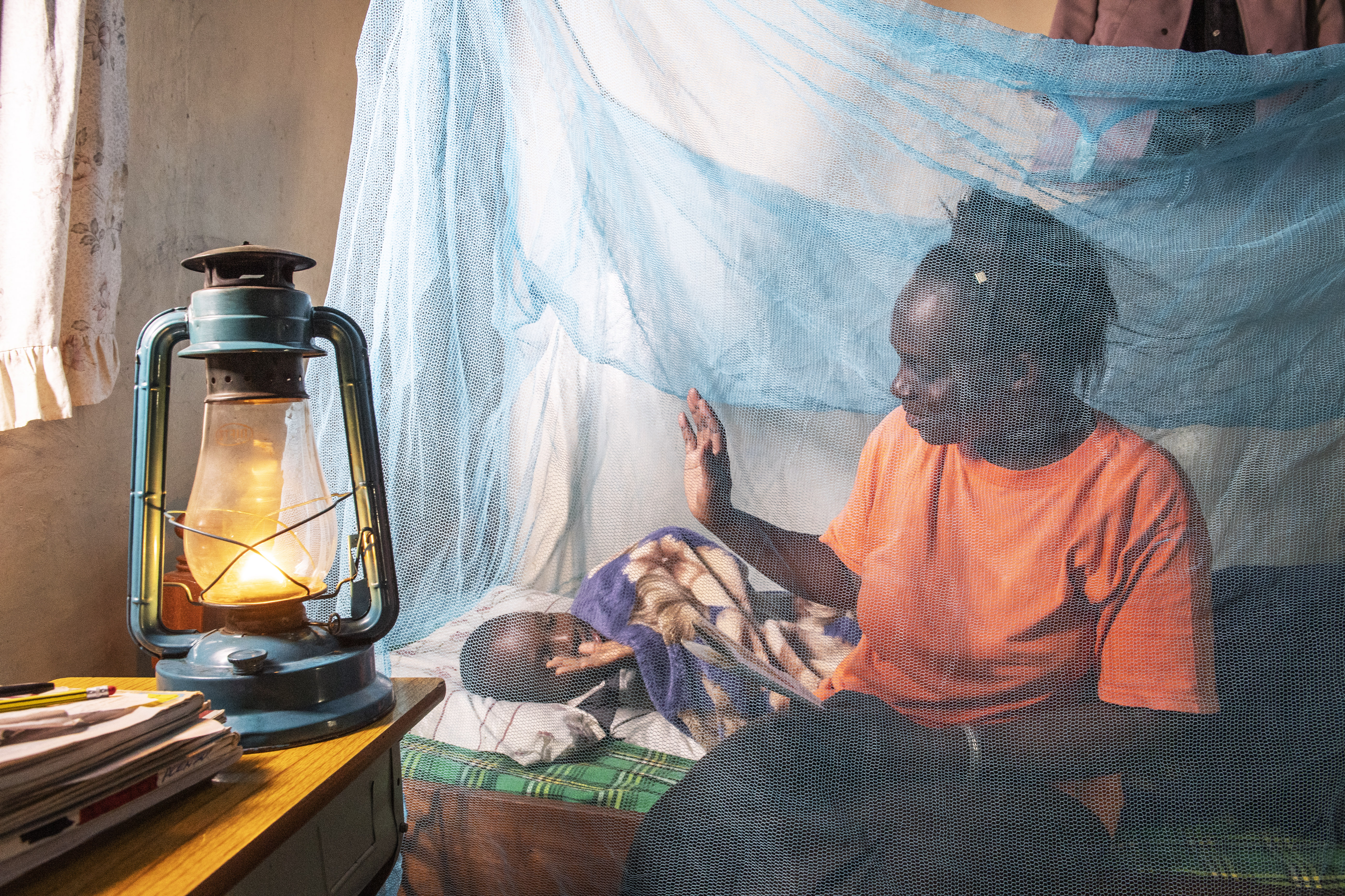 Mother and child using mosquito net in Kenya