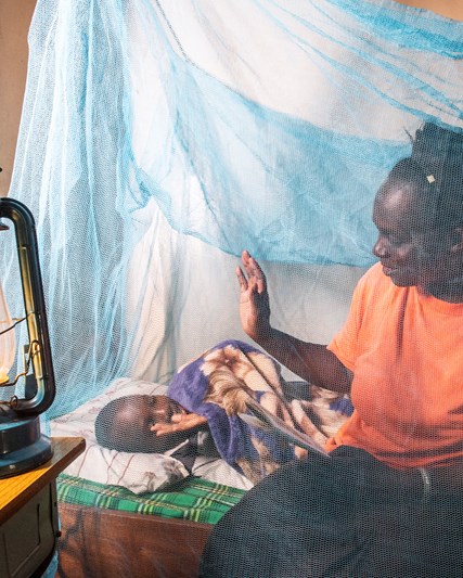 Mother and child using mosquito net in Kenya