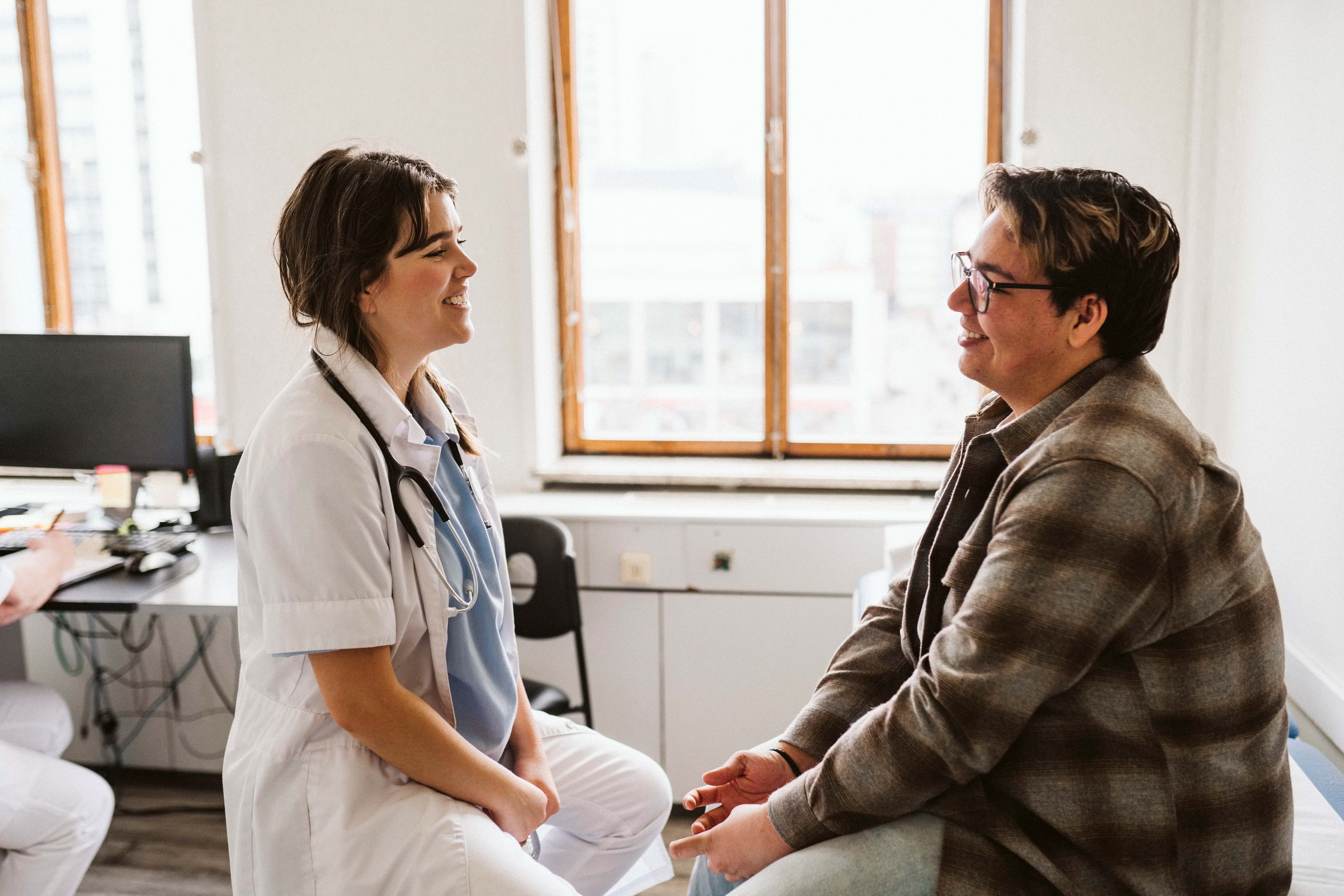 Medical professional and patient looking at each other smiling