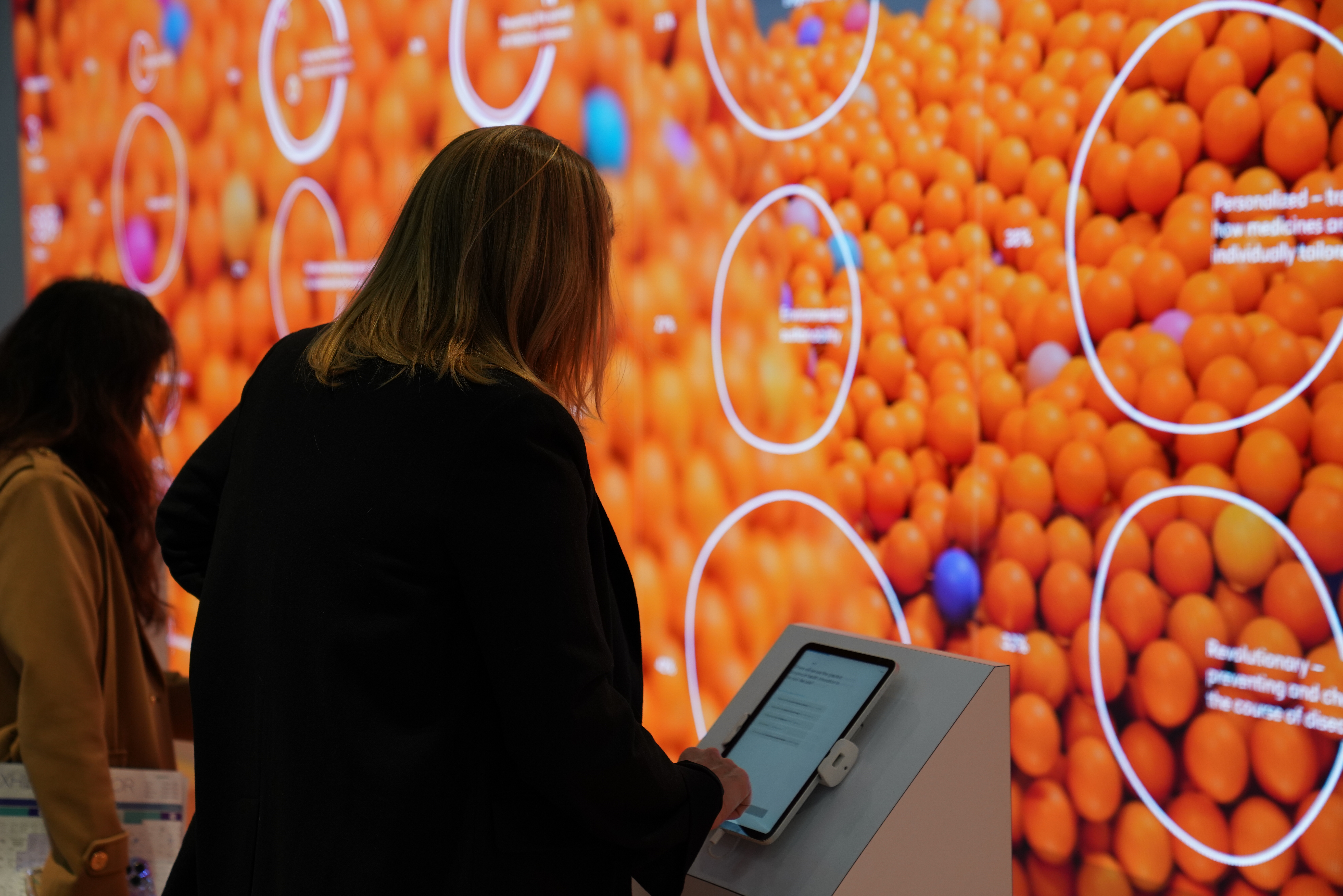 Women on tablet at a GSK stand at BIO conference