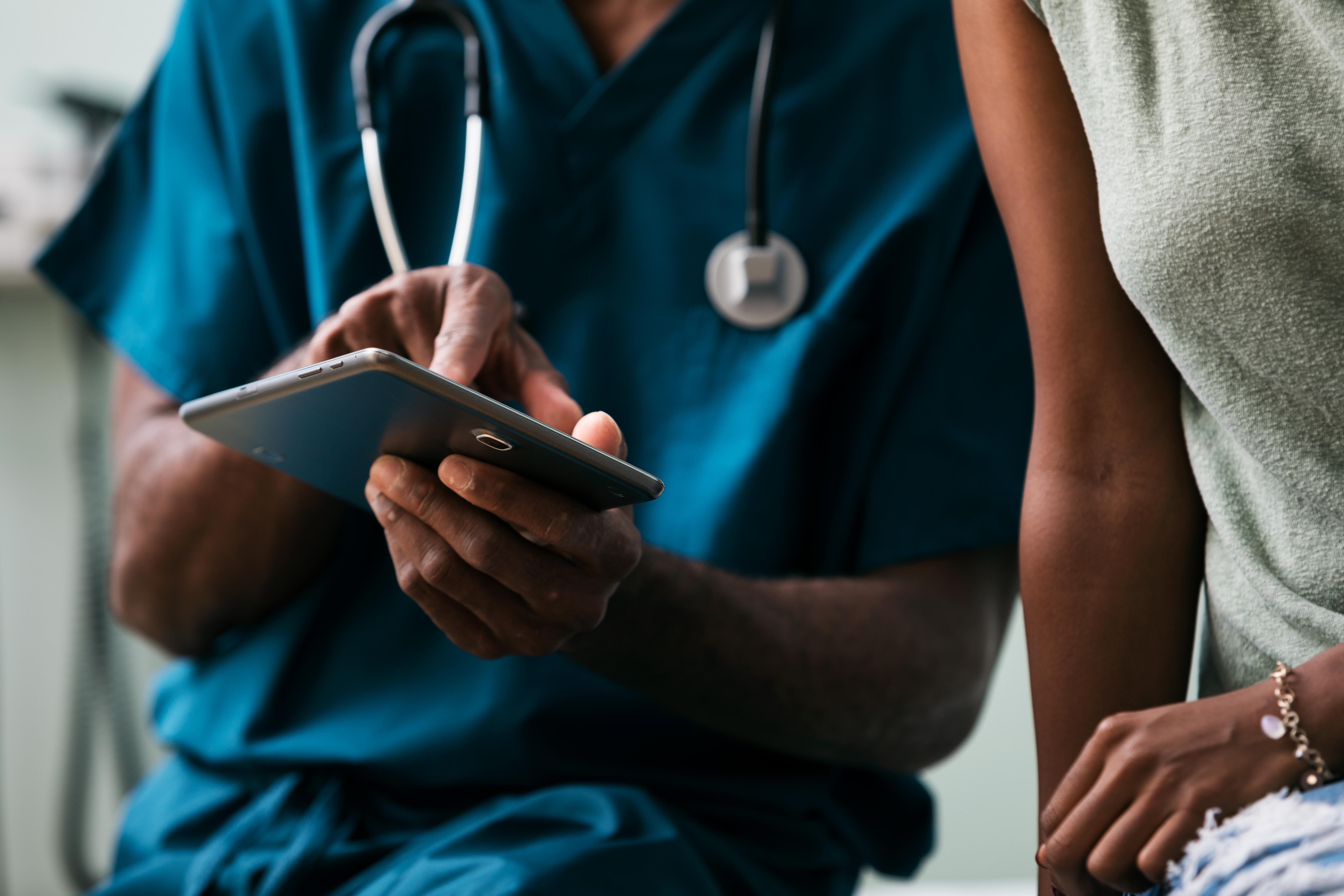 Healthcare professional shows patient information on device