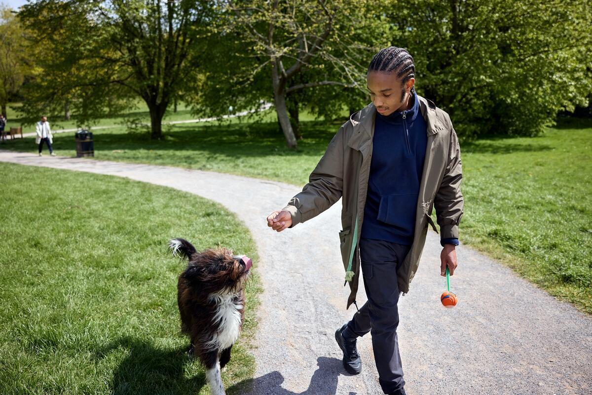 Young male patient walking a dog in park