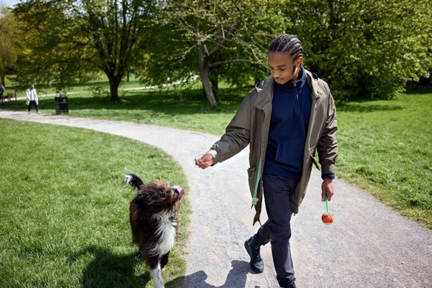 Young male patient walking a dog in park