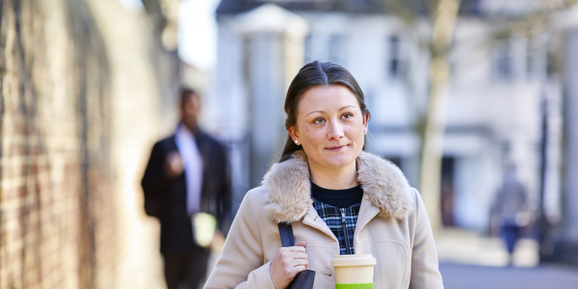 GSK employee walking to work while holding a coffee