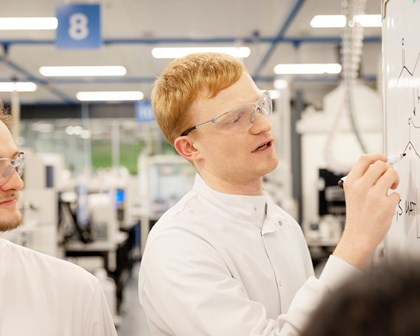 R&D scientist developing and discussing chemistry formulas in smart laboratory.