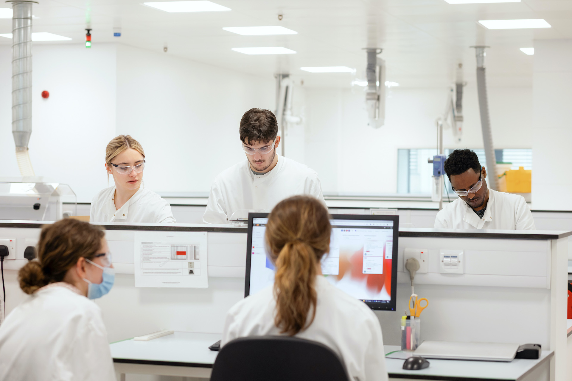 GSK quality lab team discussion around screens.