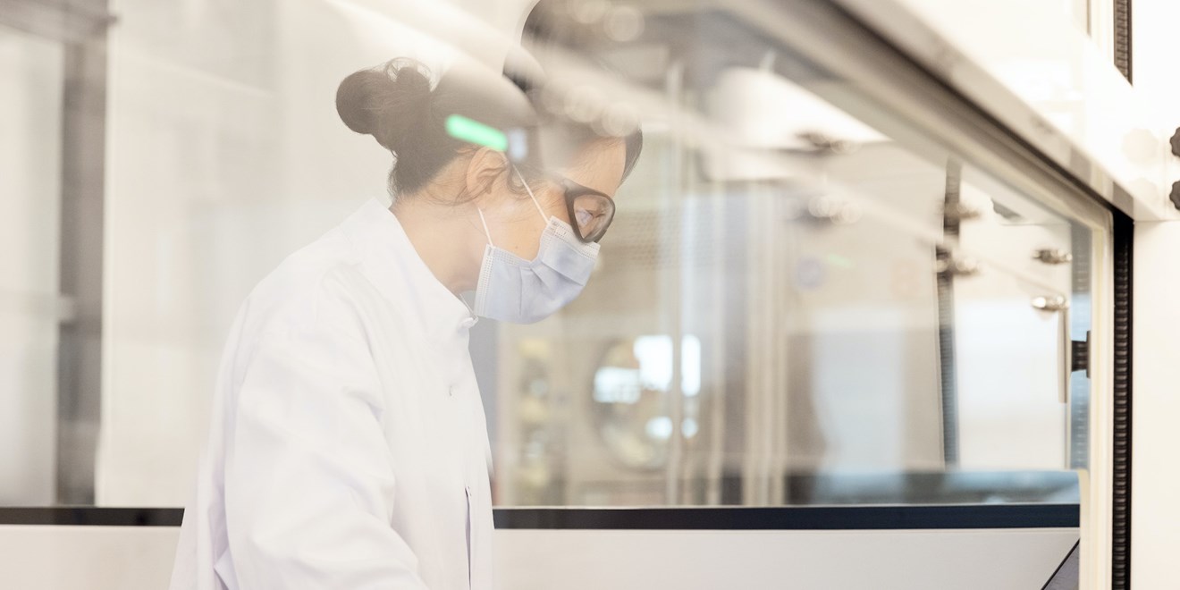 Unoccupied laboratory space with research desks and lab coats hung-up.