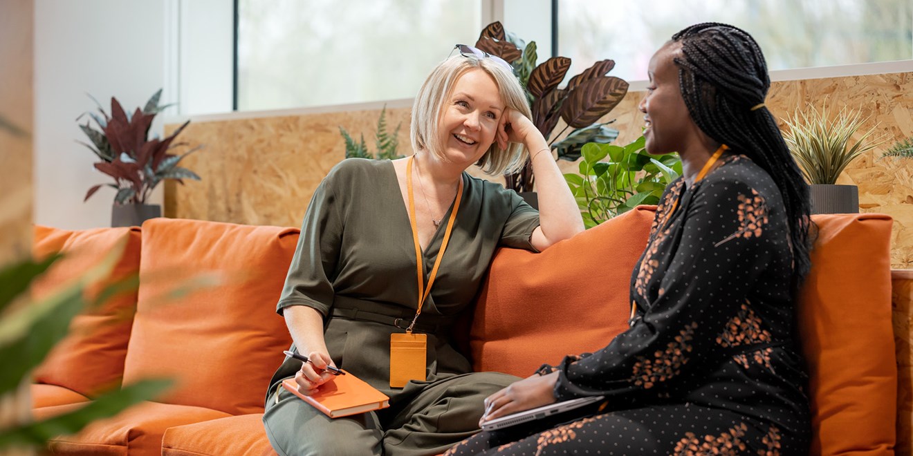 Two women speaking on a couch