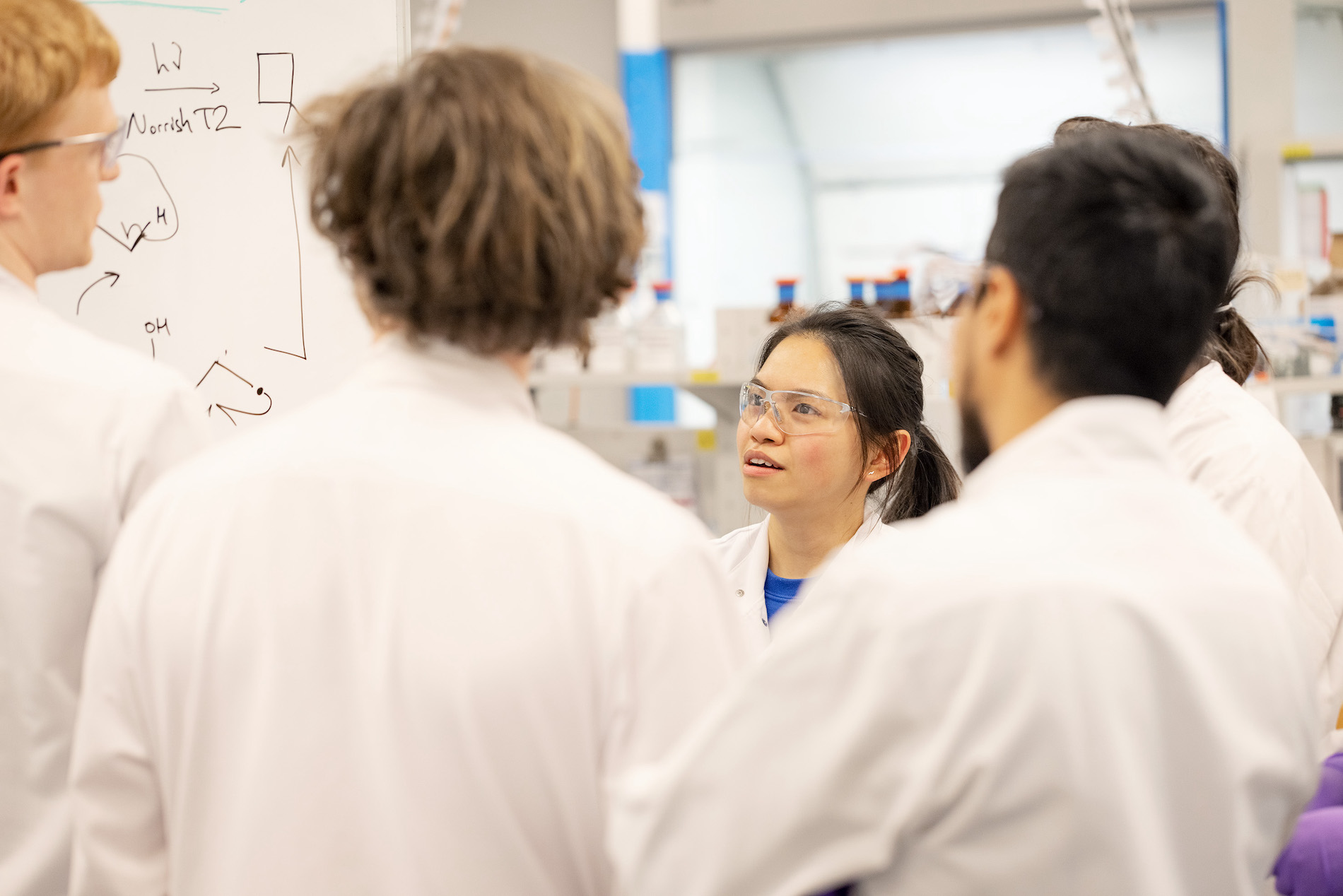 Group of employees in labcoats talking