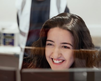 Woman and man smiling at a computer