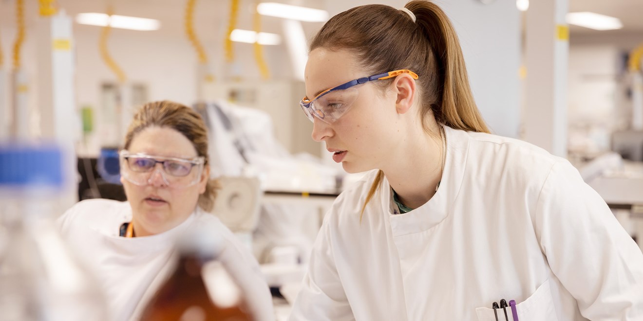 Two woman in labcoats conducting research in laboratory