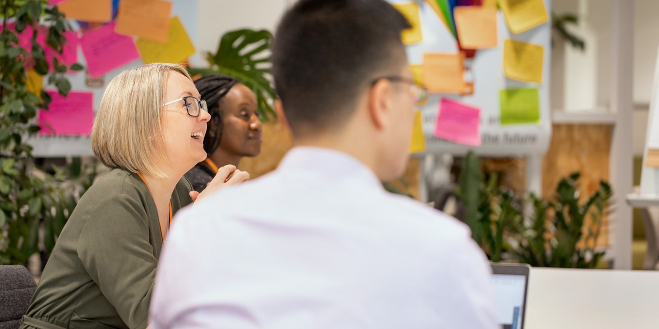Woman laughing during meeting with other employees