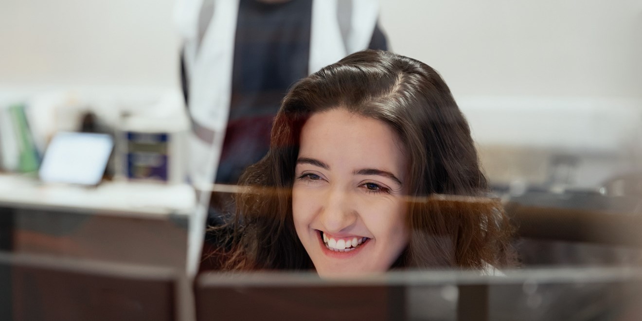 Woman and man smiling at a computer