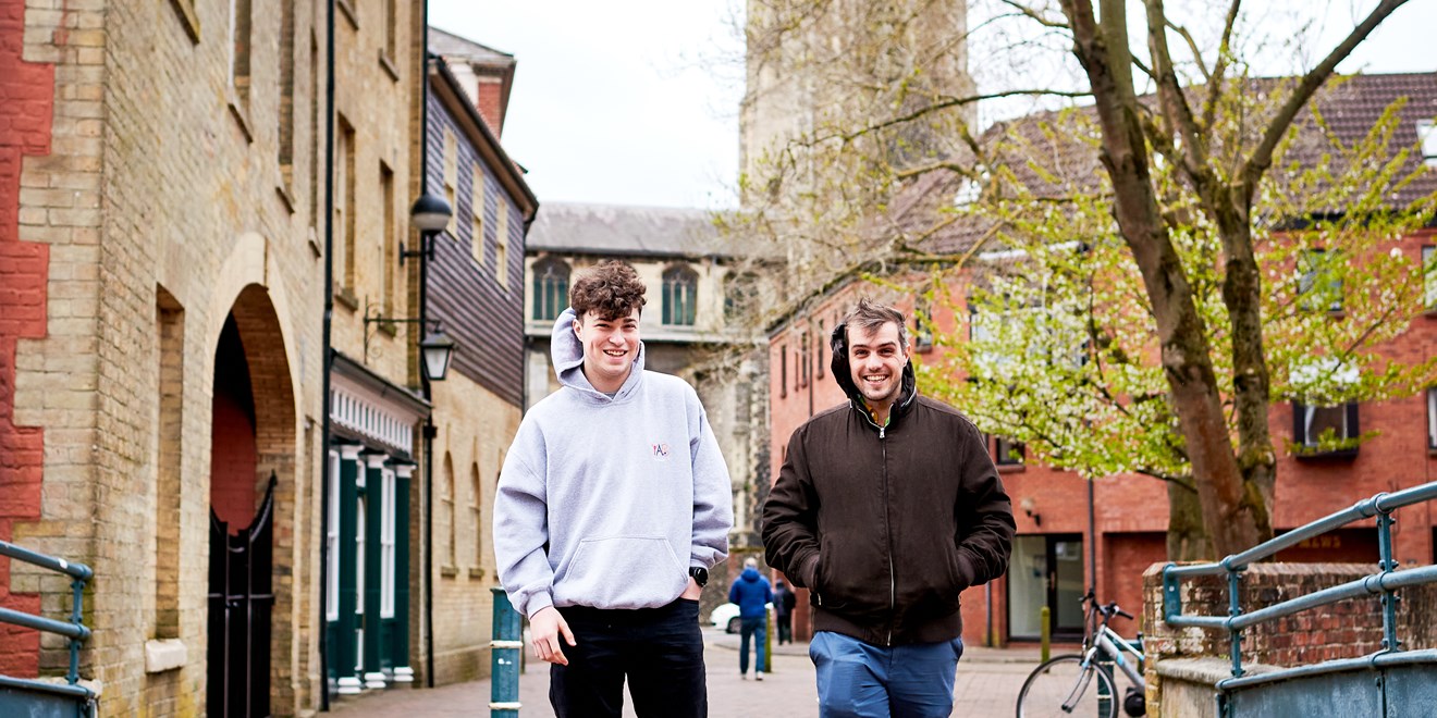 Two people walking down a pedestrian walkway
