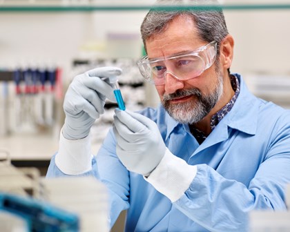 Lab worker examining a blue vial