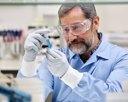 Scientist examining a vial