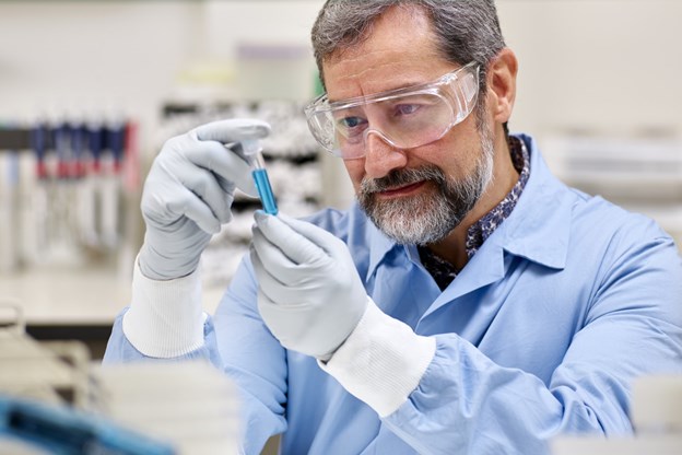 Scientist examining a vial