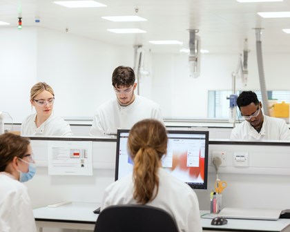 Five lab workers carrying out tasks