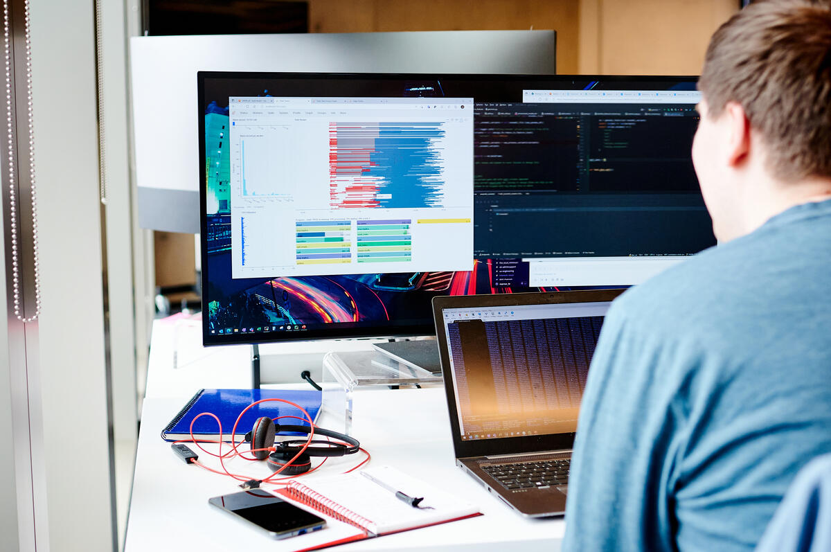 Man looks at data on computer screens