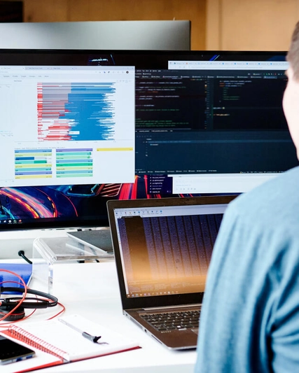 Man looks at data on computer screens