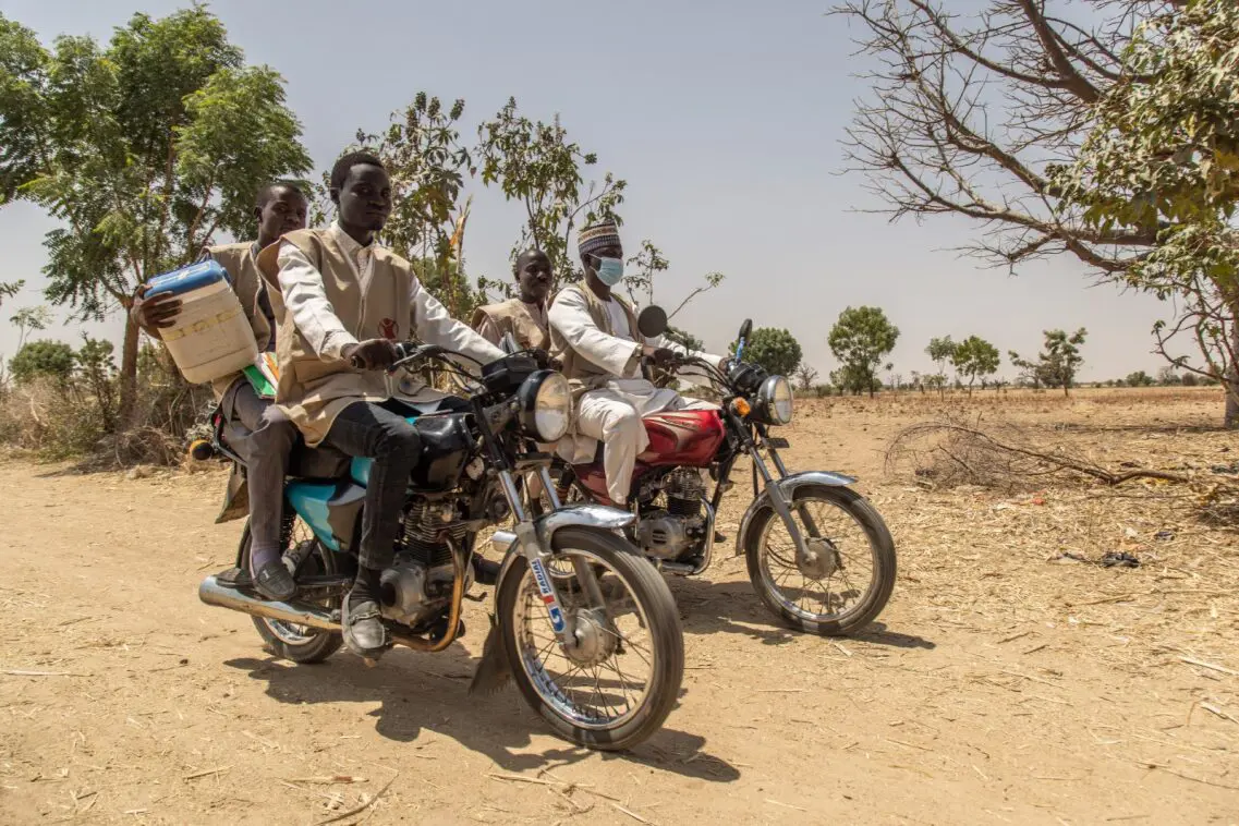 Four people sat on motorbikes in Africa