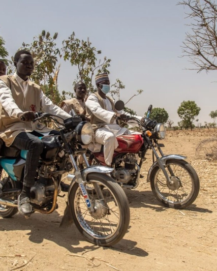 Four people sat on motorbikes in Africa