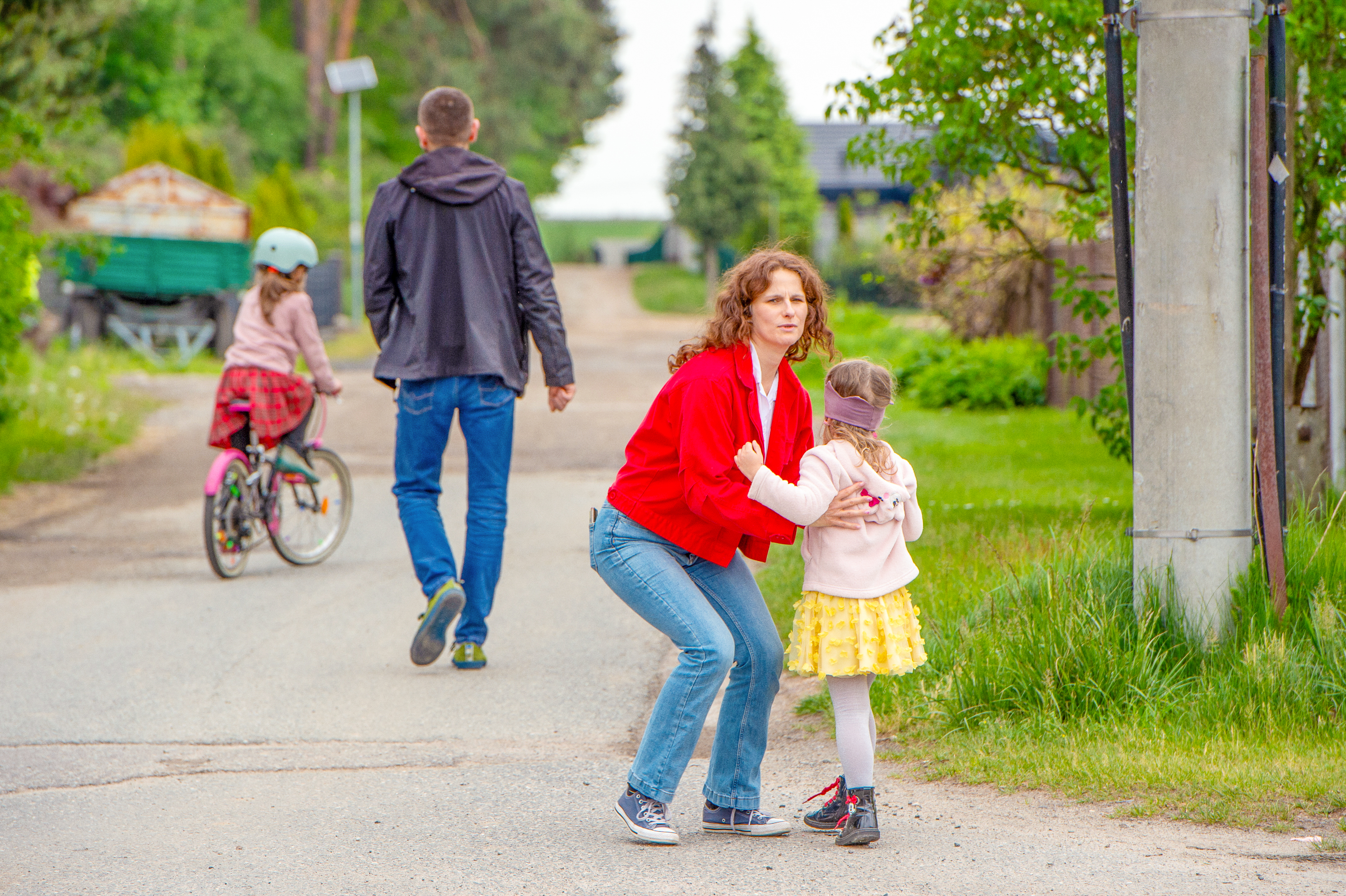 Natalia carrying her daughter with her husband and other daughter walking in the background