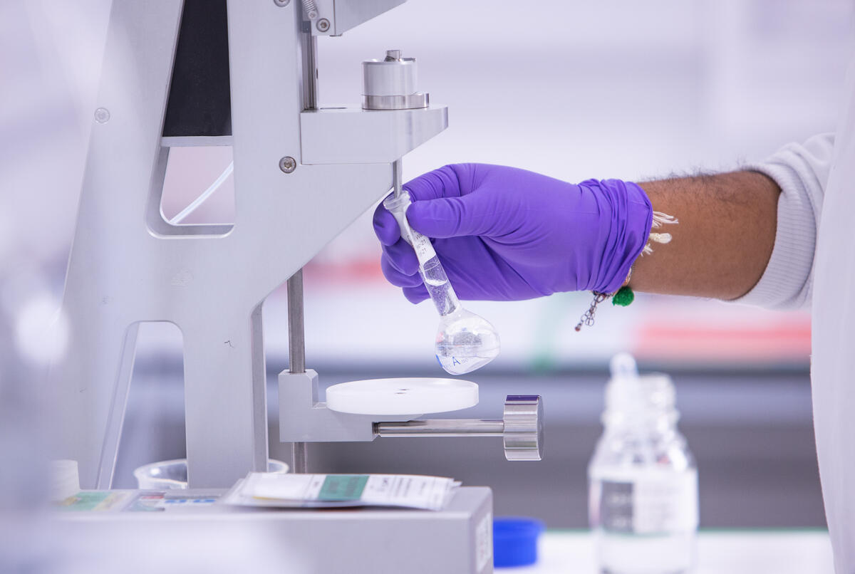 Close up of a scientist working in a lab holding lab glass