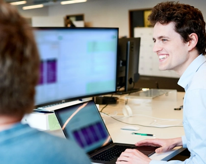 Man at desk with laptop and screen