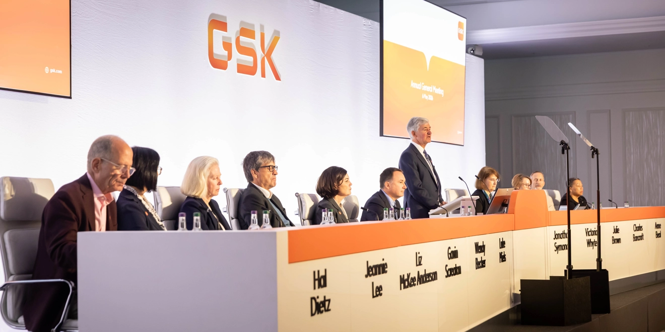 GSK Board on stage at AGM listen to Chair, Jon Symonds speaking