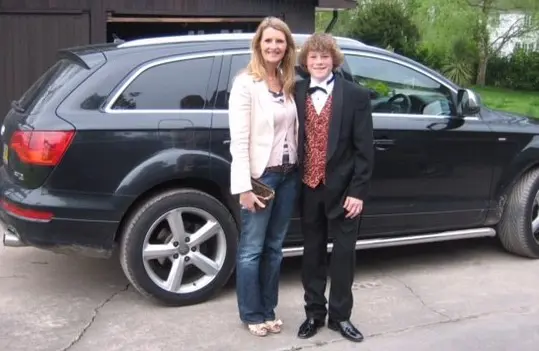 Image shows photograph of Michelle with her son Ryan, then aged 14, standing in front of a black car ahead of school ball