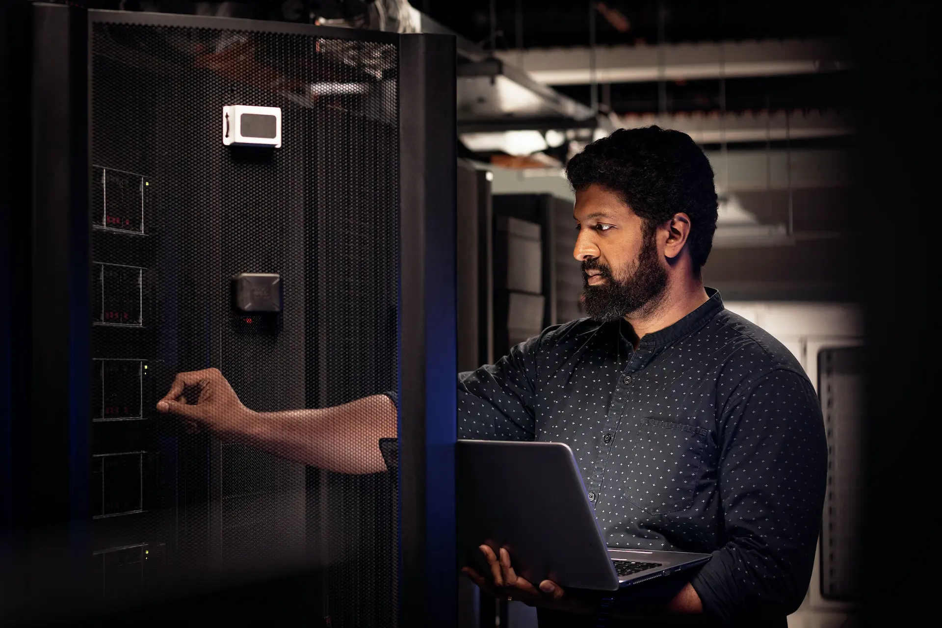 Man holding laptop at data centre