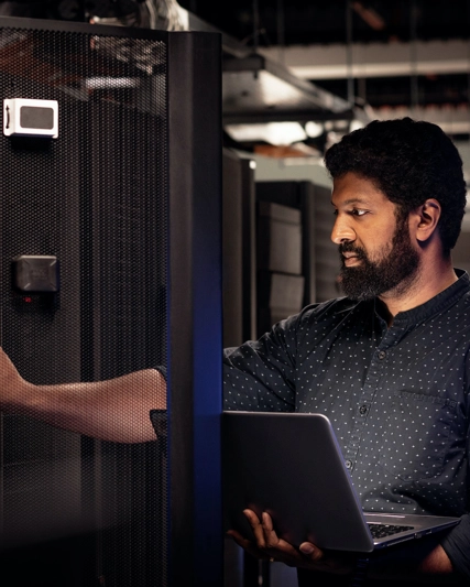 Man holding laptop at data centre