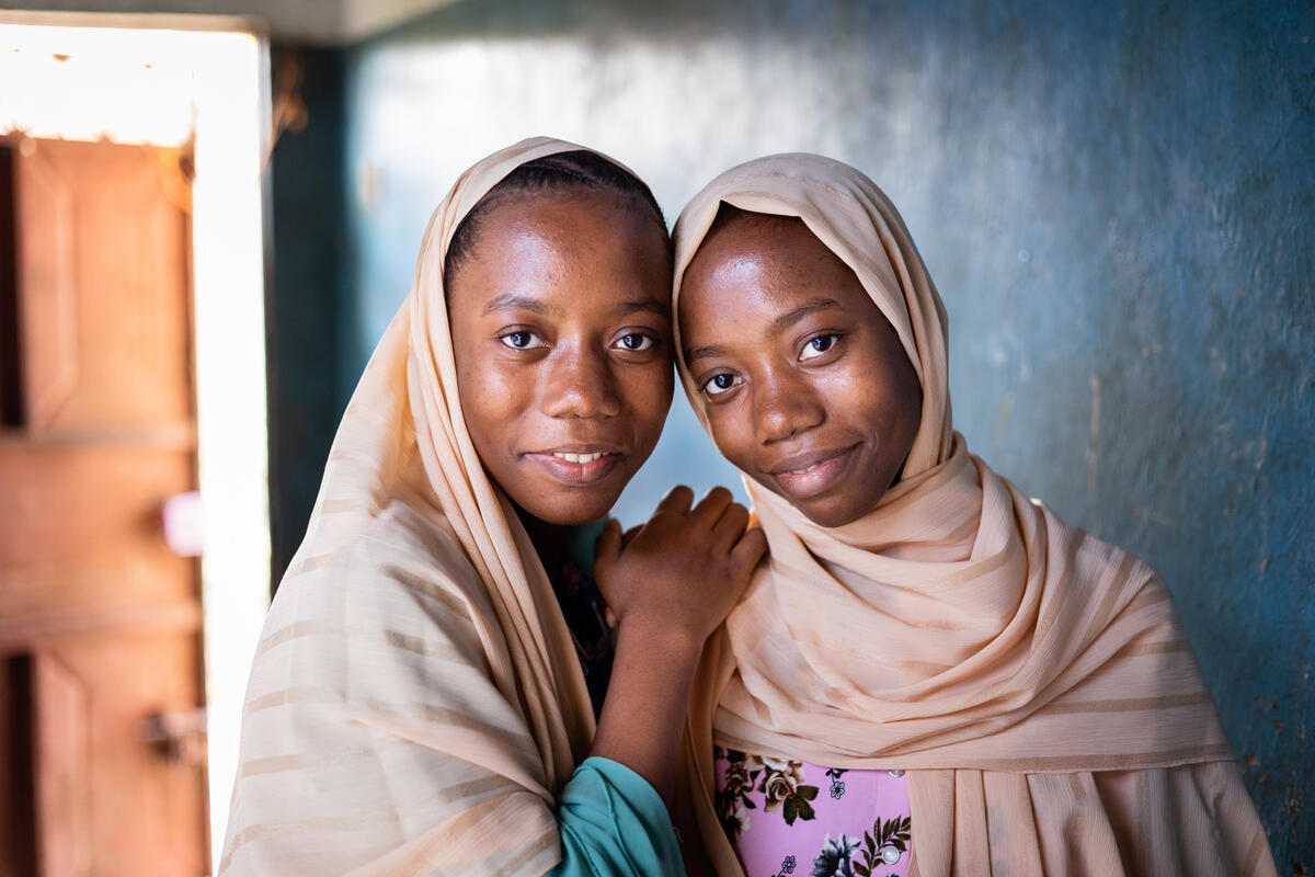 Two sisters in Zanzibar living with neglected tropical diseases looking at camera smiling