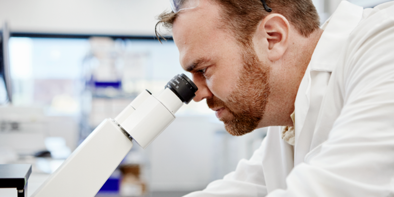 man looking through microscope