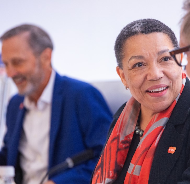 GSK Chair of Corporate Responsibility Committee Anne Beal smiles, Charles Bancroft in background