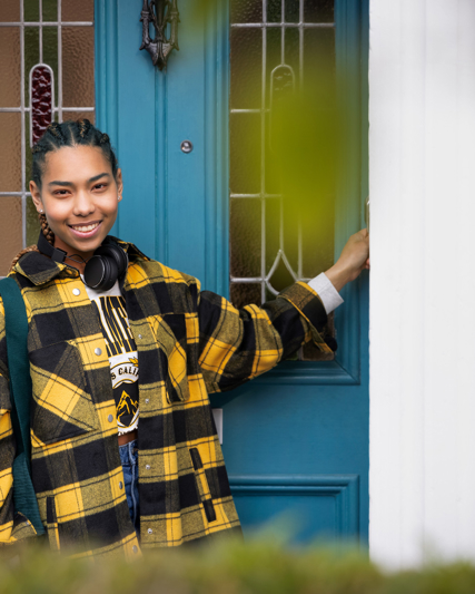 Person smiling while entering their home