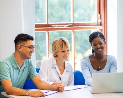 three people working on a laptop