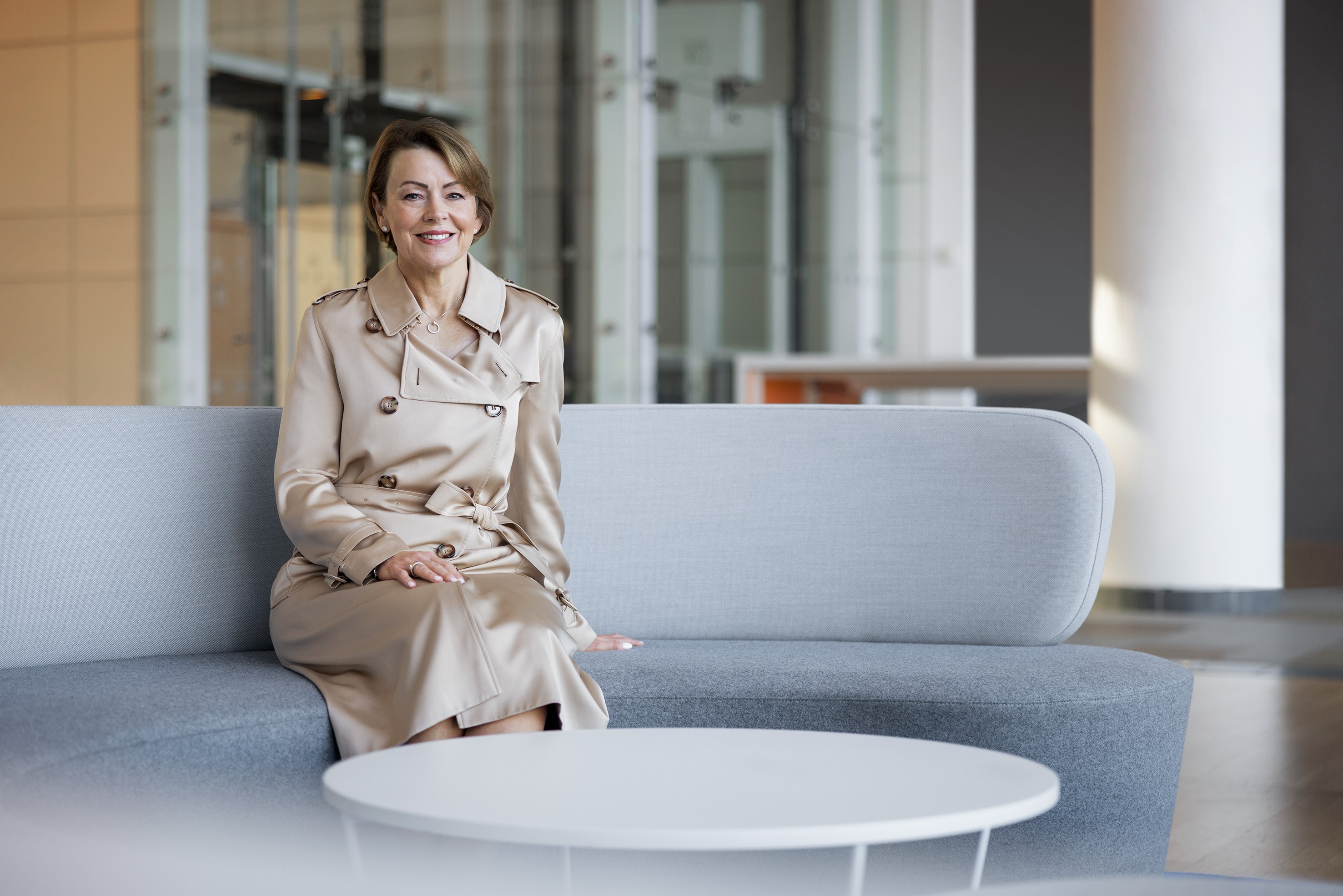 Julie Brown sat on a grey sofa smiling