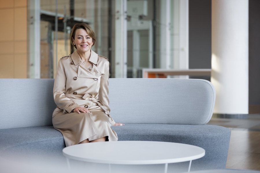 Julie Brown sat on a grey sofa smiling