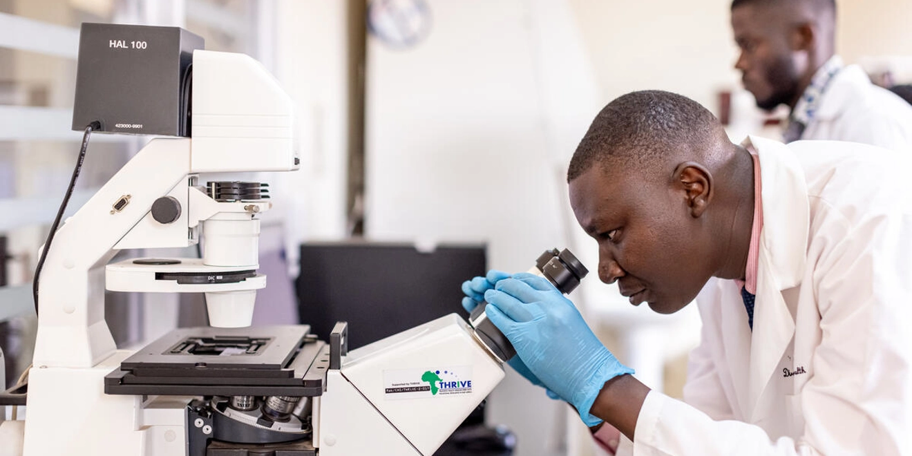 man looking in microscope