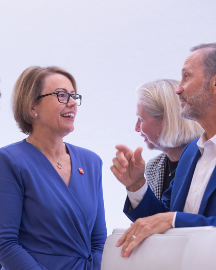 CFO Julie Brown talks to Board Director Charles Bancroft, behind stands Vishal Sikka, Liz Anderson