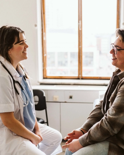 Medical professional and patient looking at each other smiling