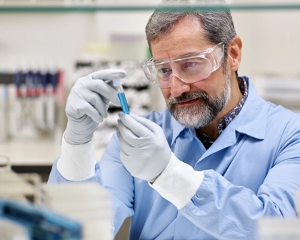 Lab worker examining a blue vial