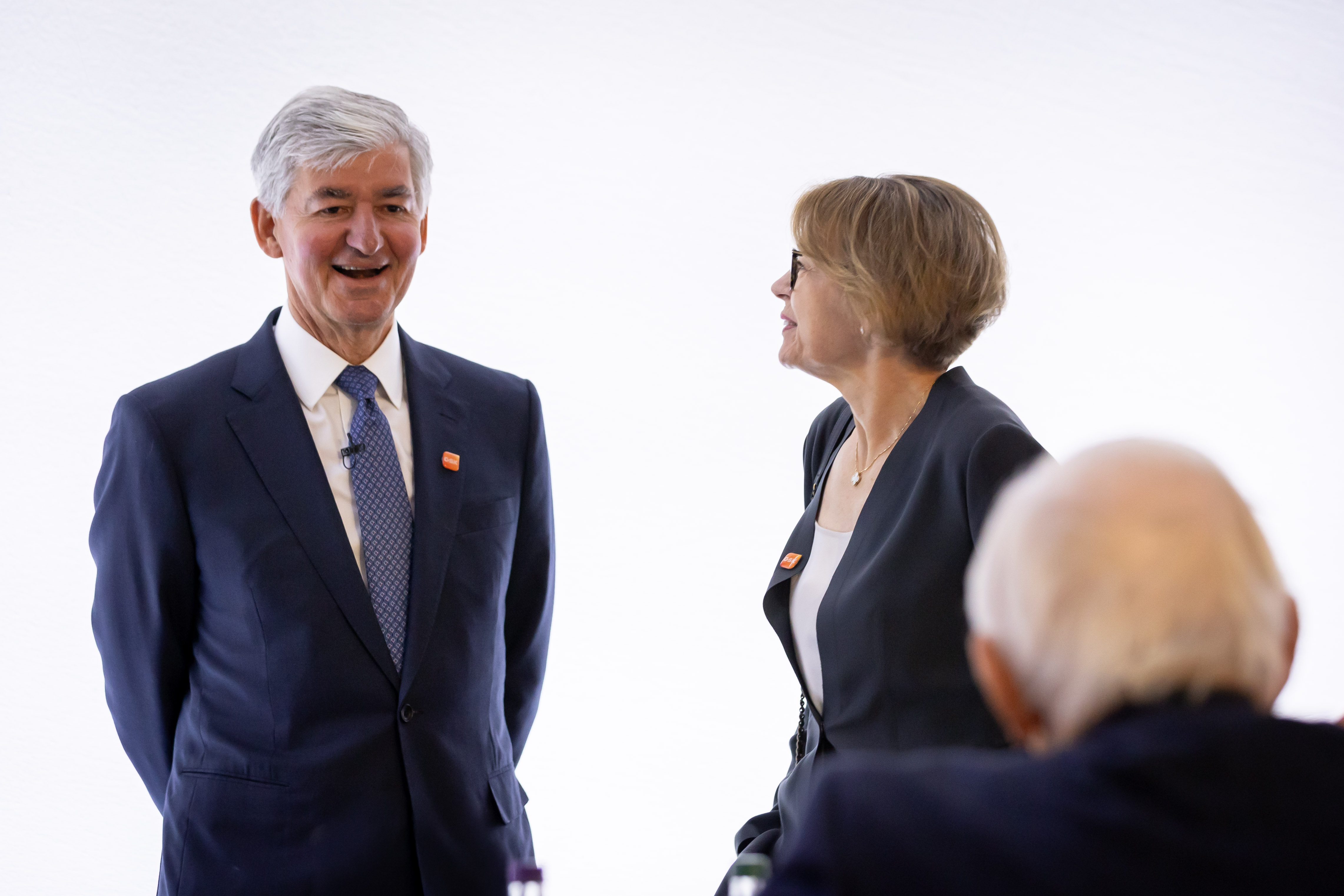 GSK Chair, Jon Symonds listens to shareholder while CFO Julie Brown looks on