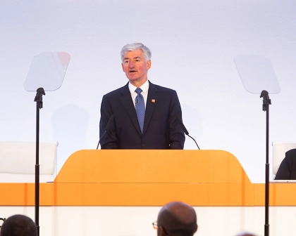 GSK Chair, Jon Symonds speaks, at podium on stage, at 2024 AGM