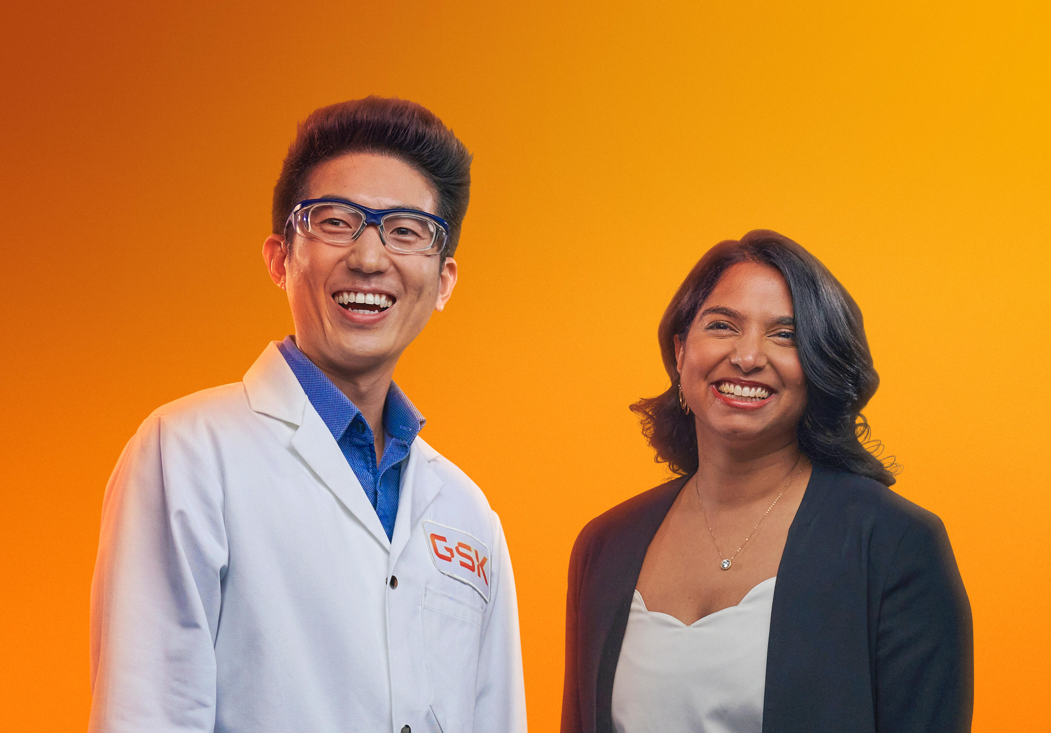 Male scientist and female dressed smartly smiling in a studio