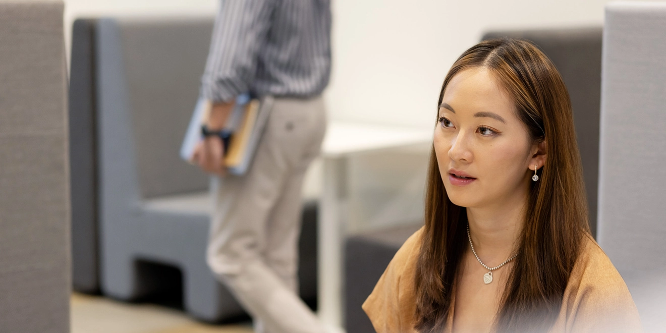 Woman works while person walks by
